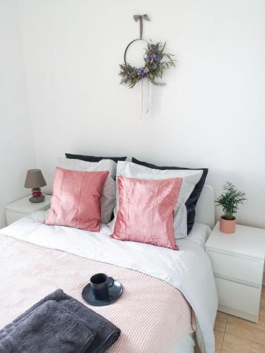 une chambre avec un lit avec des oreillers roses dans l'établissement Appartement 1BR near Monaco, à Beausoleil