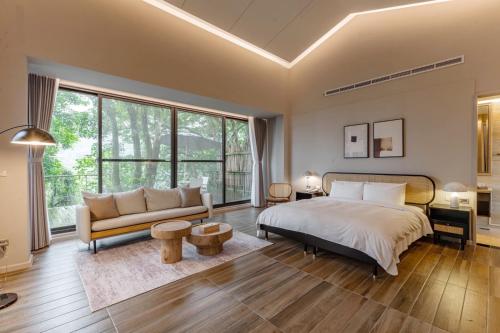 um quarto com uma cama grande e um sofá em Butterfly Valley Resort em Ruisui