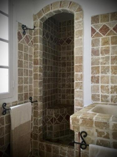 La salle de bains est pourvue d'une douche en pierre et d'un lavabo. dans l'établissement Petite maison mitoyenne au cœur de Saint tropez, à Saint-Tropez