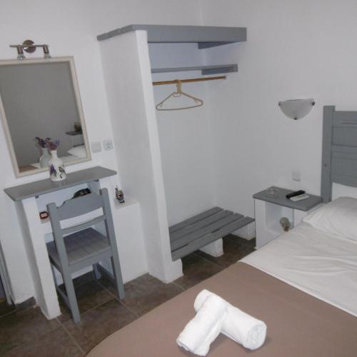a bedroom with a bed and a mirror and a chair at Skyros Panorama Studios in Skiros