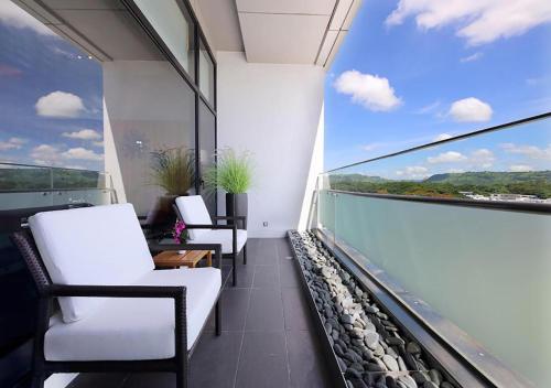 a balcony with white chairs and a large window at Midori Clark Hotel and Casino in Clark