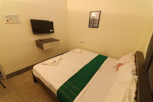 Habitación pequeña con cama y TV. en La Smart Stays, en Nāgercoil