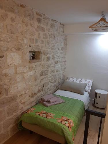 a bed in a room with a stone wall at Appartamento Gattapone 9 in Gubbio