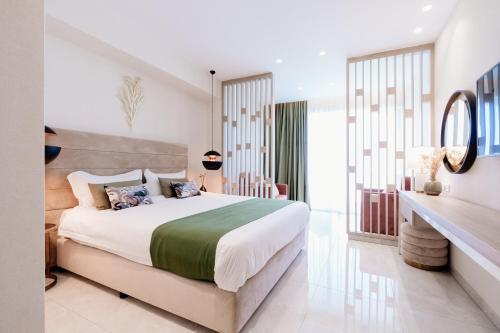 a bedroom with a large bed and a mirror at At Herbal Boutique Hotel & Spa in Protaras