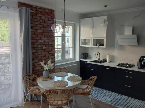 a kitchen with a table and chairs and a brick wall at APARTAMENT PIASTOWSKI in Polanica-Zdrój