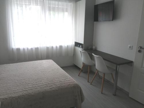 Schlafzimmer mit einem Bett, einem Tisch und Stühlen in der Unterkunft Werner Apartman in Mohács