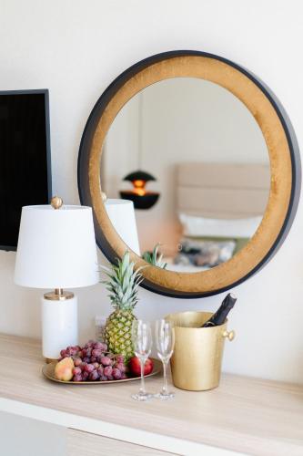 a table with a plate of fruit and a mirror at At Herbal Boutique Hotel & Spa in Protaras