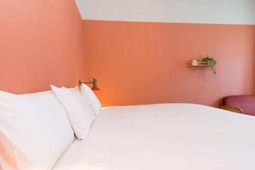 a bedroom with a white bed with orange walls at Casa Rosa Villa with Pool in Olhao Centre in Olhão