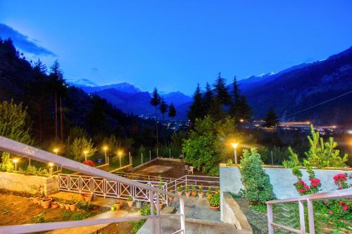 a view of a park at night with mountains at Baan by Snow City Farm in Vashisht