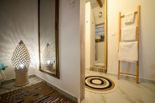 ein Badezimmer mit einem Spiegel und einem Teppich in der Unterkunft Sunset Suite Elena in Ioulis