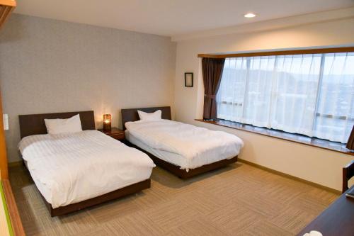 Ένα ή περισσότερα κρεβάτια σε δωμάτιο στο Aso Hotel