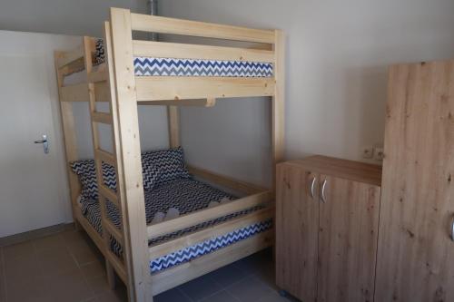 a bunk bed room with two bunk beds and a cabinet at Captains beach home in Čara