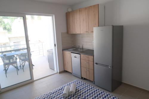 a kitchen with a refrigerator and a table with a patio at Captains beach home in Čara
