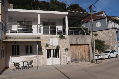 a house with a table and chairs in front of it at Captains beach home in Čara