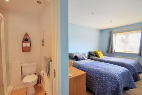 baño con 2 camas, aseo y lavamanos en Anning's View, en Lyme Regis