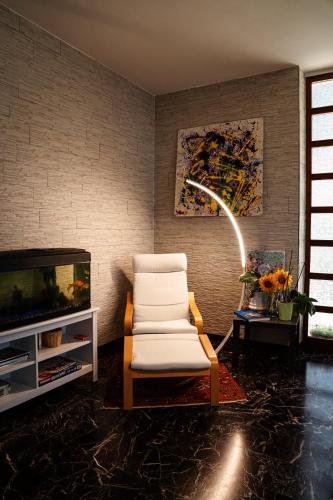 a living room with a chair and a tv at Il Girasole in Basciano
