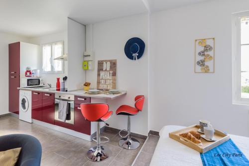 a kitchen with red chairs and a kitchen counter at Studio Bleu - Parc Astérix - Mer de Sable - Villepinte - Aéroport CDG in Vémars