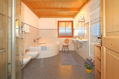 uma casa de banho com uma banheira, um WC e um lavatório. em Niglutsch Apartement Puflatsch em Castelrotto