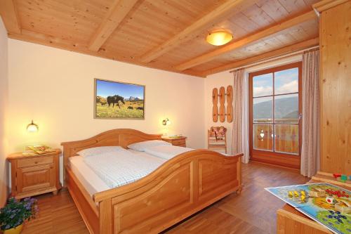 een slaapkamer met een houten bed en een raam bij Niglutsch Apartement Kastelruth in Castelrotto