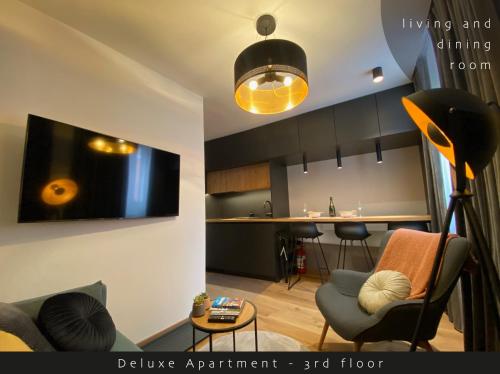 ein Wohnzimmer mit einem Sofa und einem TV an der Wand in der Unterkunft Piran Rooftop Apartments in Piran