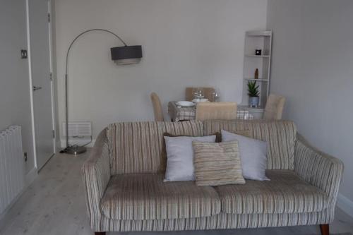 a couch with pillows sitting in a living room at 2 bed Apartment Ballycastle Seconds to Seafront in Ballycastle