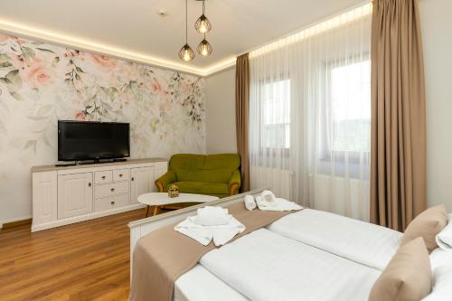 a hotel room with a bed and a tv at Servita Udvarház Eger in Eger