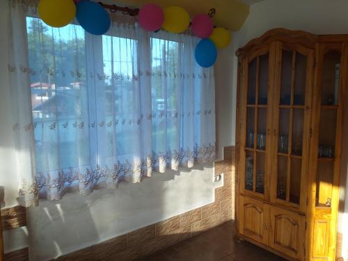 a room with a window with curtains and balloons at Vacation Home Yoanna in Tryavna
