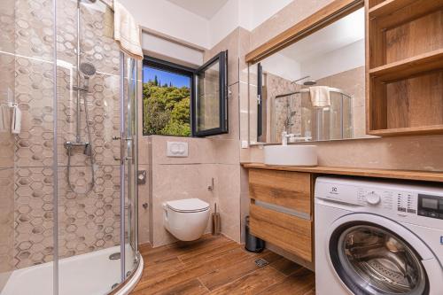 a bathroom with a washing machine and a shower at Casa Bella in Lopud