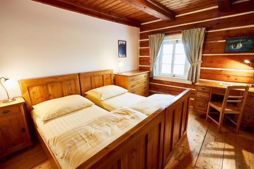 a bedroom with two beds and a desk in it at Panský dům - Jizerka in Jizerka