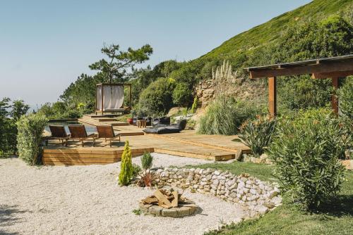 a garden with a person sitting on the sand at Luxury Beach Villa in Ericeira