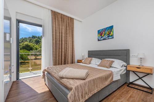 a bedroom with a large bed and a balcony at Casa Bella in Lopud