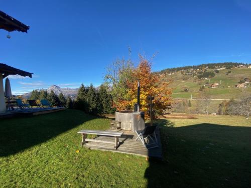 a picnic table on the grass in a field at La Ferme des Georgières "Séjour en tout compris" in Notre-Dame-de-Bellecombe