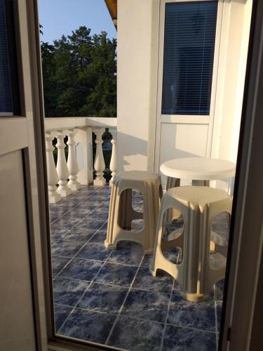 a balcony with two tables and two stools at Vacation Home Yoanna in Tryavna