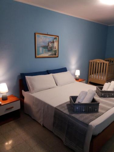 a blue bedroom with a bed and a baby crib at Casa Narciso tra mare e canyon ad Avola in Avola