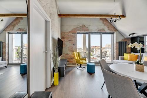 uma sala de estar com mesa e cadeiras em Grano Residence - Pool, Sauna, SPA & Parking by Downtown Apartments em Gdansk