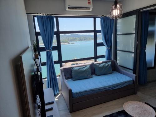 een woonkamer met een bank en een groot raam bij Nana Homestay - Jesselton quay in Kota Kinabalu