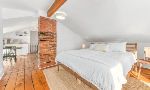 1 dormitorio con cama y pared de ladrillo en The Flats East, en Wellington