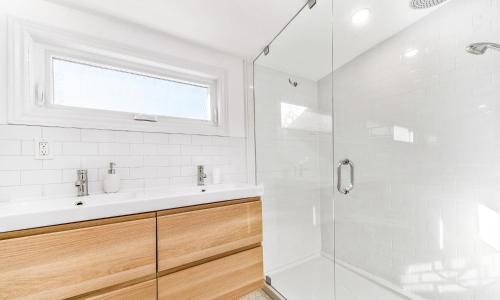 a white bathroom with a sink and a shower at The Flats East in Wellington