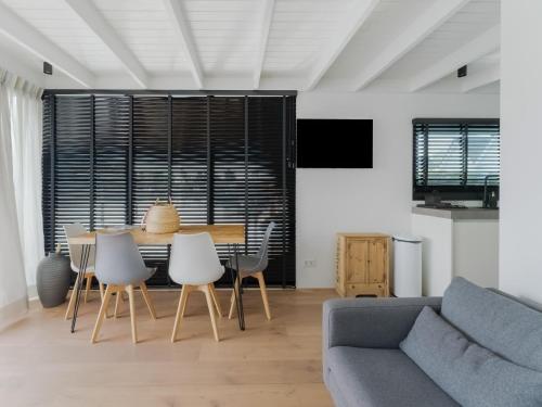 a living room with a couch and a table and chairs at Houseboat in Stavoren with Waterfront Views in Stavoren