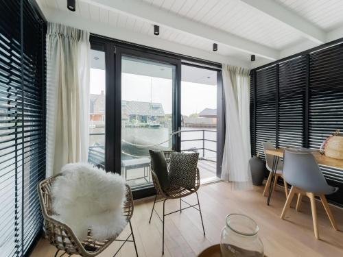 a living room with a table and chairs and windows at Houseboat in Stavoren with Waterfront Views in Stavoren