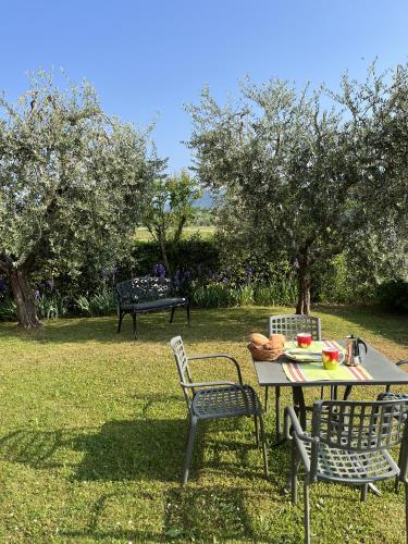 a table and chairs in a field with trees at Residence Il Melograno in Manerba del Garda