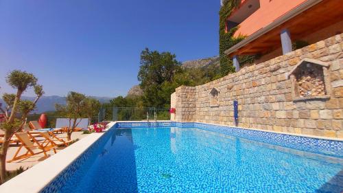a swimming pool in front of a building at Blue Mediterranean Apartments in Sveti Stefan