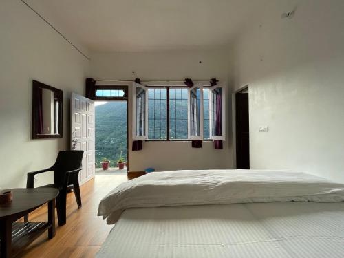 1 dormitorio con cama, escritorio y ventana en Green Mountain Homestay - Birthi Falls near Munsyari, en Munsyari