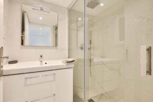 une salle de bain blanche avec un lavabo et une douche dans l'établissement Mer et Soleil - Carré d'or - 4 piéces - Centre ville - Plages à 300 m, à Nice