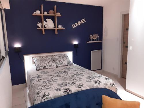 um quarto com uma cama com uma parede azul em L'Escale Marine : Centre ville/ Plage em Bandol