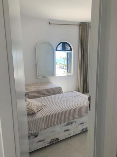 a bedroom with two beds and a window at Charmant logement front port et Mer in Port El Kantaoui