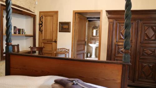 a bedroom with a canopy bed and a bathroom at Au relais du croquant du Périgord, classée 3 étoiles in Cendrieux