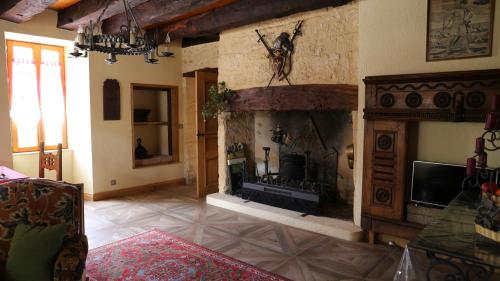 a living room with a fireplace and a tv at Au relais du croquant du Périgord, classée 3 étoiles in Cendrieux