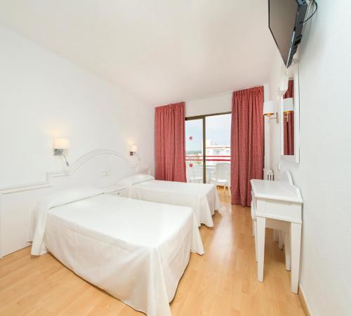 a hotel room with two beds and a window at Coral Star Hotel in San Antonio Bay