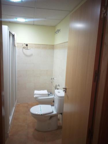 a bathroom with a toilet and two towels at Apartamentos Cuesta de la Cruz in Caravaca de la Cruz